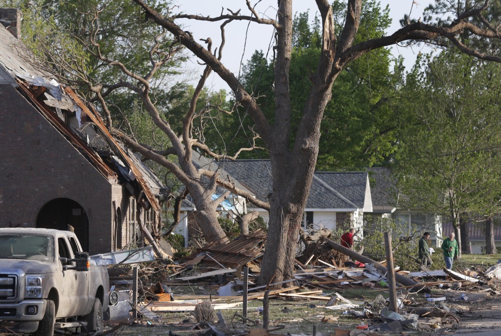 Residents view damage from a Sunday night tornado in Baxter Springs, Kan., Monday. The tornado left a trail of shattered homes, twisted metal and hanging power lines.