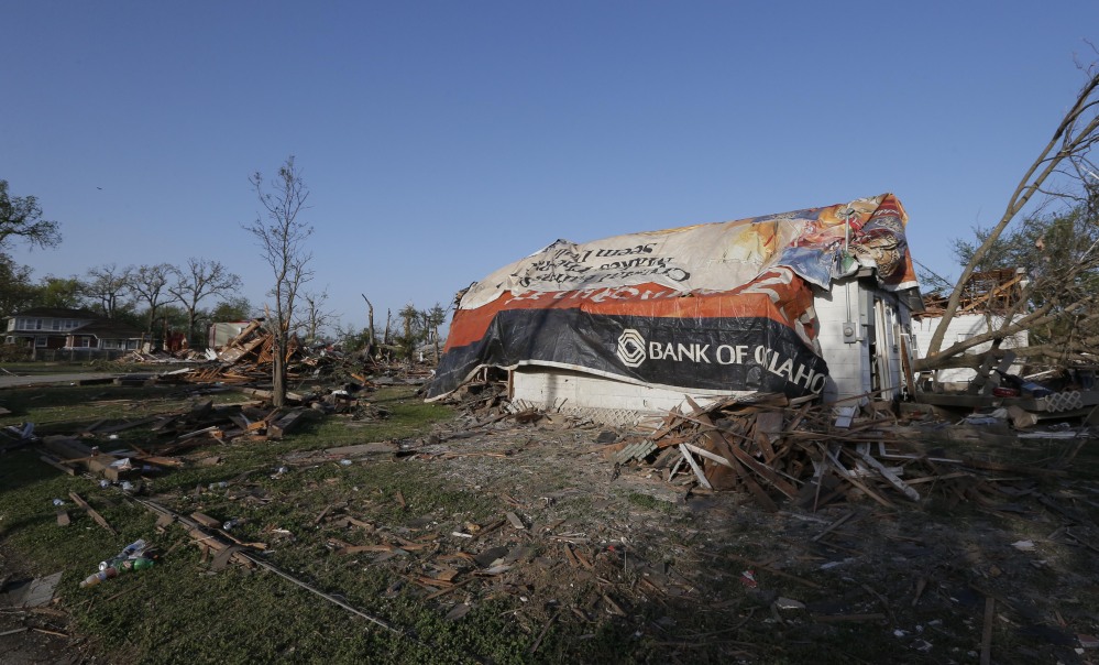A tornado-damaged home is covered by tarps in Baxter Springs, Kan., Monday. The tornado left a trail of shattered homes, twisted metal and hanging power lines. One person died, but it was not clear whether the death was related to the storm.