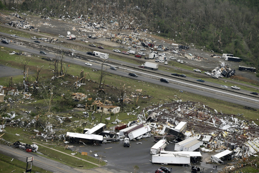 Traffic passes on Interstate 40 between destroyed businesses in Mayflower, Ark., on Monday after a tornado struck the town late Sunday.