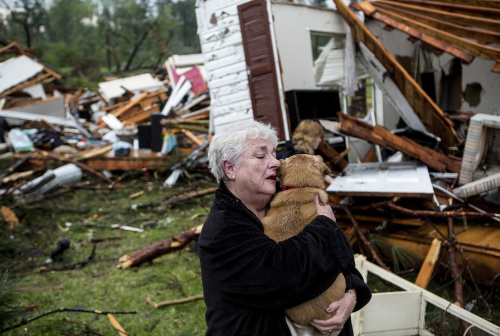 Constance Lambert embraces her dog after finding it alive when returning to her destroyed home in Tupelo, Miss., Monday. Lambert was at an event away from her home when a tornado struck.