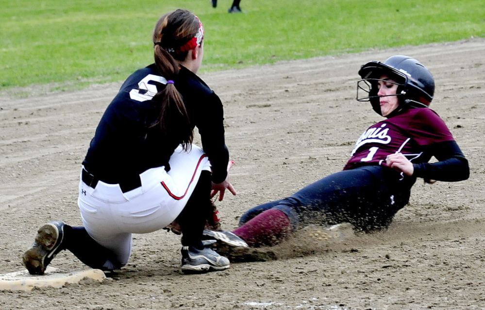 Staff photo by David Leaming Nokomis' Mikayla Charters slides into third base in time as Winslow's Brooke Haskell attempts to tag her out in Winslow on Monday, April 28, 2014.