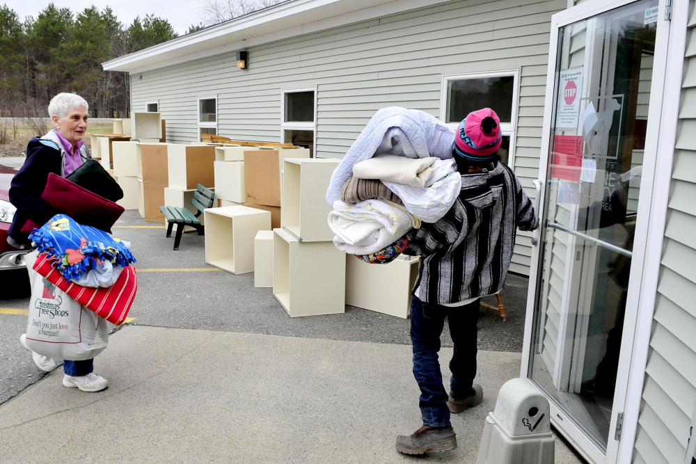 WELCOME DONATIONS: Humane Society Waterville Area employee Luis Mauser holds the door for Jane Bird, who donated bedding for animals at the shelter on Monday. In the background are boxes for cats stored outside and will be discarded because of a ringworm outbreak.