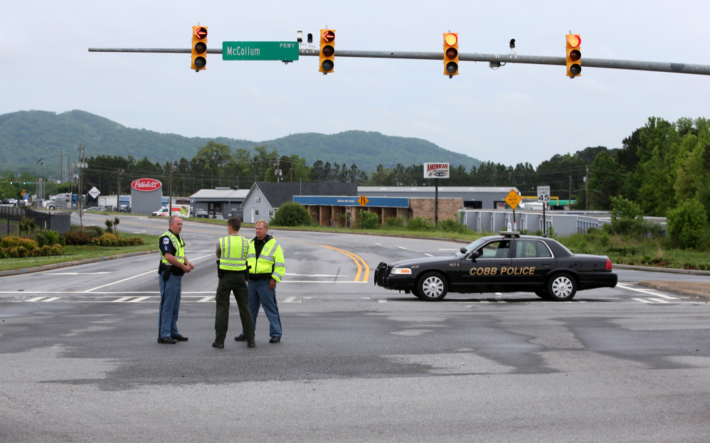 Cobb County police block off Old U.S. Highway 41 after a shooting at the Airport Road FedEx facility Tuesday morning in Kennesaw, Ga.