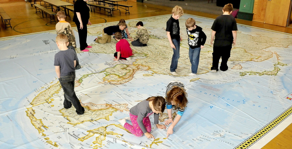 LOST IN SPACE: Students at Garrett Schenck School in Anson explore a giant map of Asia courtesy of the Maine Geographic Alliance on Tuesday.