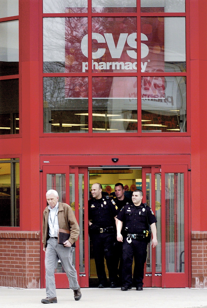 BAD CALL: Waterville police including, from left, Detective Alan Perkins, Sgt. Brian Gardiner and officers Damon Lefferts and Kyle McDonald exit the CVS store in Waterville on Wednesday after responding to a bomb threat. The building was searched and nothing was found.