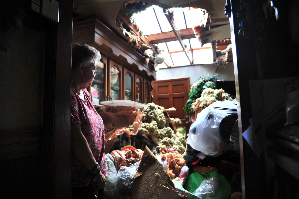 Faye Busby looks over her living room after a tornado ripped part of the roof off of her home in Graysville, Ala., Tuesday.