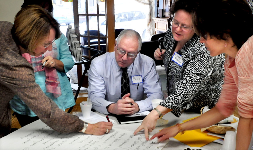 PROBLEM SOLVERS: A forum involving multiple agencies was held in Waterville to deal with the problem of youth homelessness on Wednesday. Ann Bouchard, left, Waterville Police Chief Joseph Massey, Cindy Manson and Elizabeth Hartford consult with their selections of issues during a group strategy session.