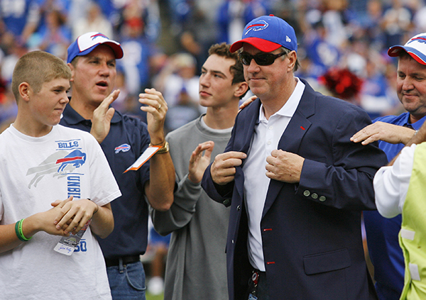 Former Buffalo Bills quarterback Jim Kelly receives his jacket during ceremonies honoring him and fellow team Wall of Fame members at halftime of a game against the Carolina Panthers, in Orchard Park, N.Y., last fall.