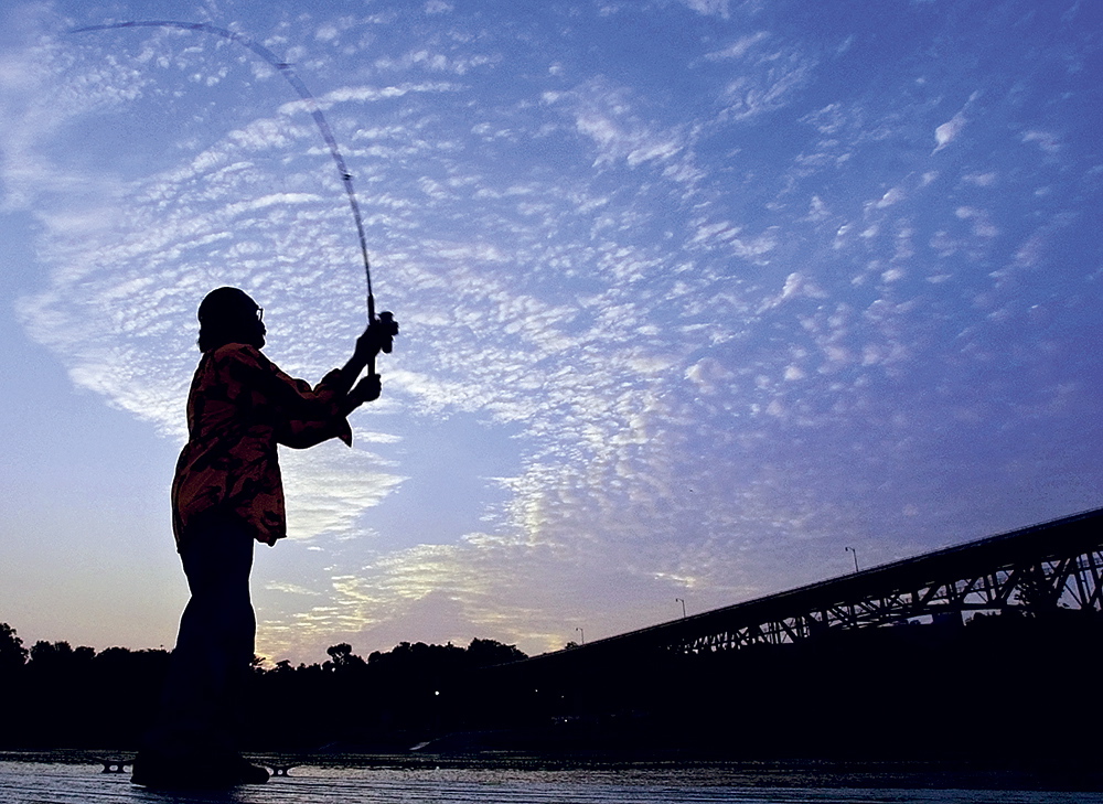 DAWN’S EARLY LIGHT: In this photo taken in July 2006, a fisherman gets up before dawn to cast into the Kennebec River from the floating dock in Augusta Waterfront Park. Even at 5:22 a.m., there were several fishermen on the shore and more in boats going after stripers.