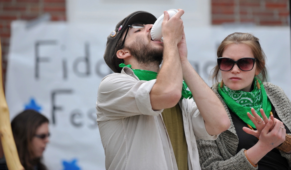 Delicious: Kyle Sareyani, left, finishes a plate of lemon avocado fiddlehead flatbread at the third annual Fiddlehead Festival in Farmington on Saturday.