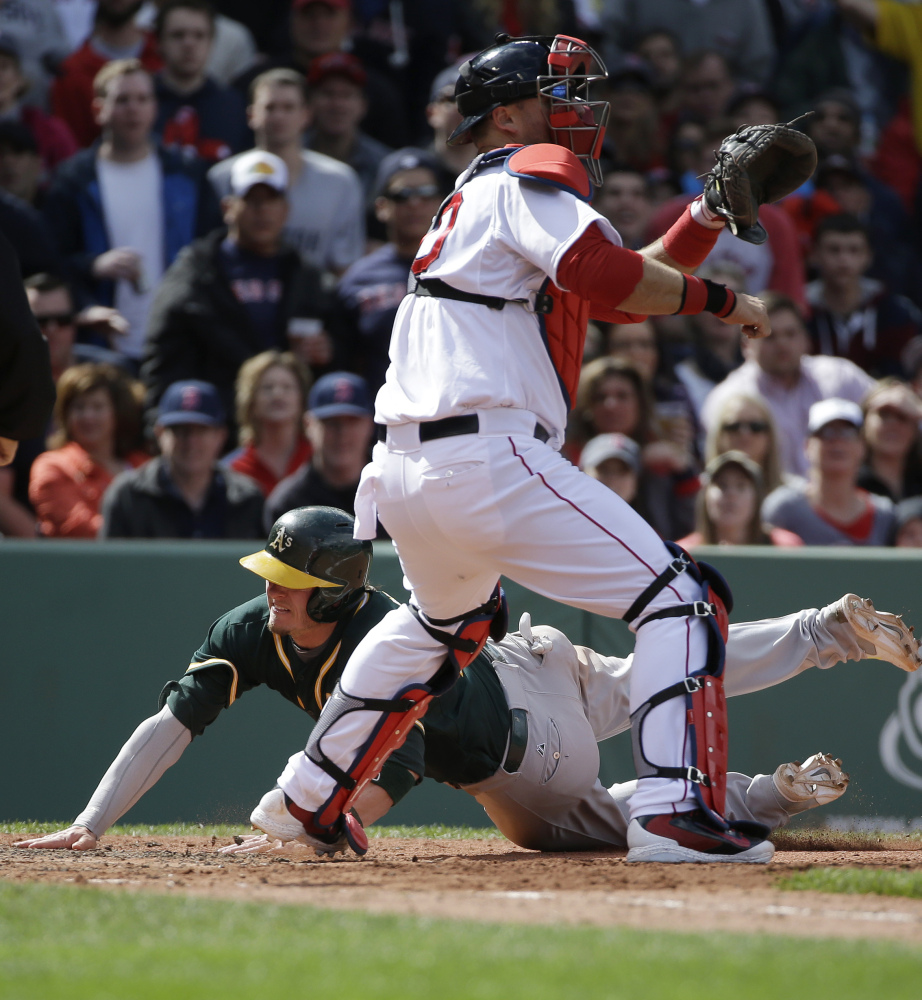 Oakland’s Josh Donaldson slides home ahead of the tag by Red Sox catcher A.J. Pierzynski to score on a sixth-inning double by Yoenis Cespedes, who later drove home the winning run in the 10th inning with a bases-loaded infield single.