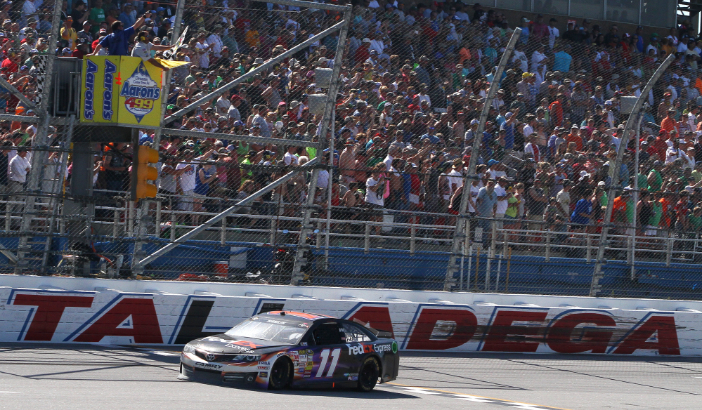 Denny Hamlin (11) takes the checkered flag under caution during the NASCAR Aaron’s 499 Sprint Cup series auto race at Talladega Superspeedway on Sunday in Talladega, Ala.