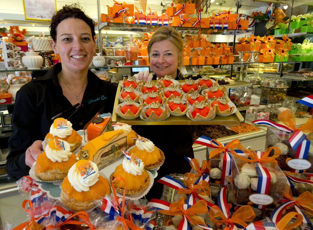Sandra Terpstra, left, and Linda Clewits hold trays of cakes at an Arnold Cornelis pastry shop in Amsterdam. The restaurant chain Dunkin’ Donuts is expanding in Europe.