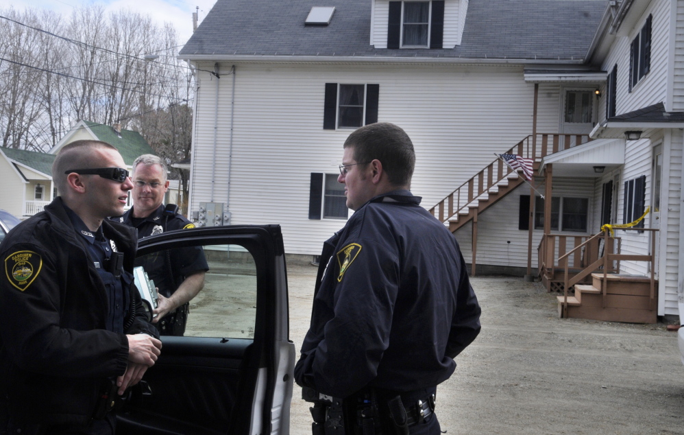 Investigation: Gardiner police confer Monday while guarding an apartment building on Cannard Street that State Police detectives searched. Neighbors said investigators examined an apartment shared by father and son Leroy Smith II and Leroy Smith.