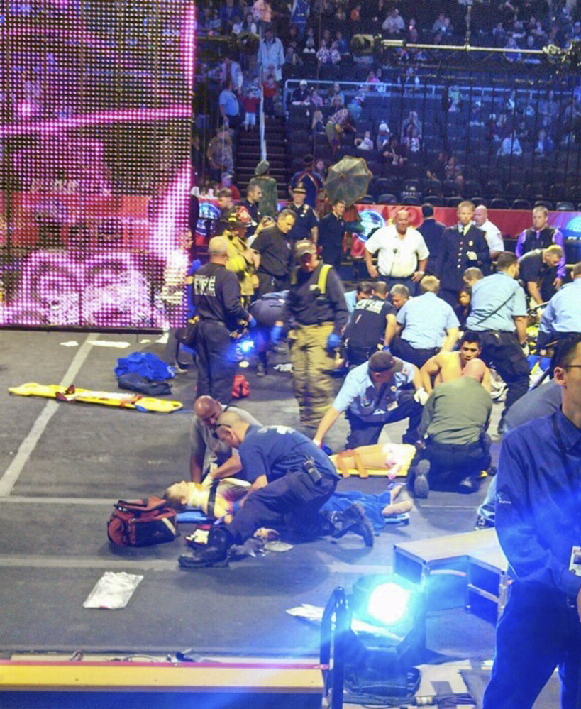 In this photo provided by Rose Viveiros, first responders work at the center ring after a platform collapsed during an aerial hair-hanging stunt at the Ringling Brothers and Barnum and Bailey Circus, Sunday in Providence, R.I. At least nine performers were seriously injured in the fall, including a dancer below, while an unknown number of others suffered minor injuries.