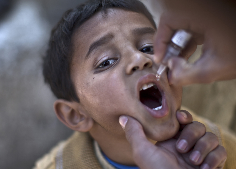A Pakistani child is vaccinated against polio by a health worker in Islamabad, Pakistan, in this November 2013 photo. The ongoing effort to erradicate polio costs about $1 billion a year.