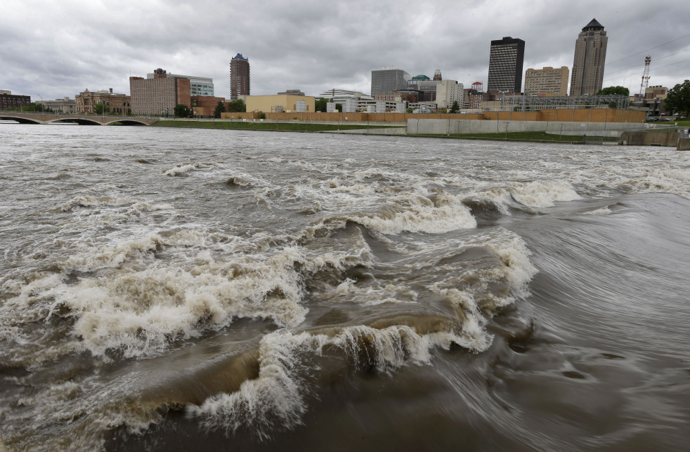 In this May 30, 2013, file photo, water splashes over the Center Street Dam in the swollen Des Moines River in downtown Des Moines, Iowa.