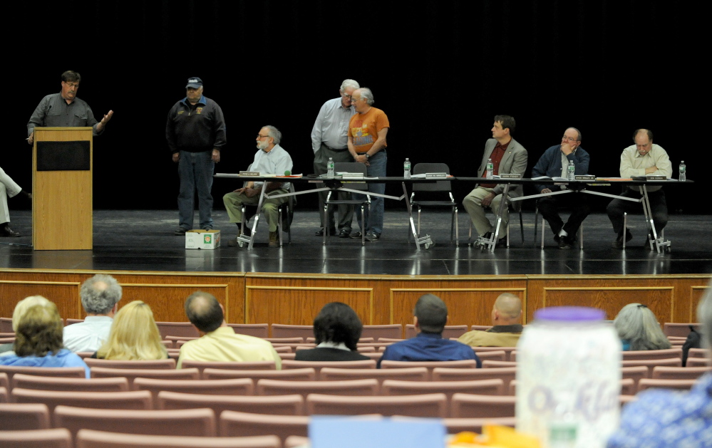 Staff photo by Michael G. Seamans Oakland town council members sit on the stage as of the performing arts center during the Oakland Town Meeting at Messalonskee High School in Oakland on Tuesday, May 6, 2014.