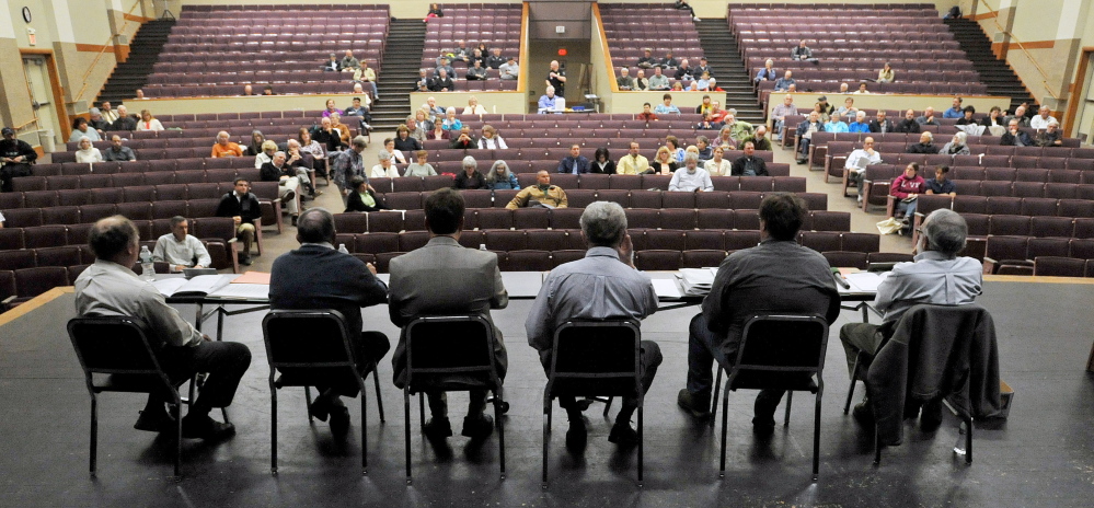 Staff photo by Michael G. Seamans Oakland town council members sit on the stage as residents spot the seats of the performing arts center during the Oakland Town Meeting at Messalonskee High School in Oakland on Tuesday, May 6, 2014. Town meeting attendance has been on the decline according to town officials.