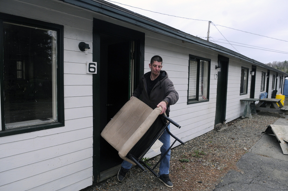 MOVING: Mike Johnson removes his belongings Tuesday from his former room at the Country Village Motel and Apartments in Augusta. The complex was closed after a sewer pipe broke.