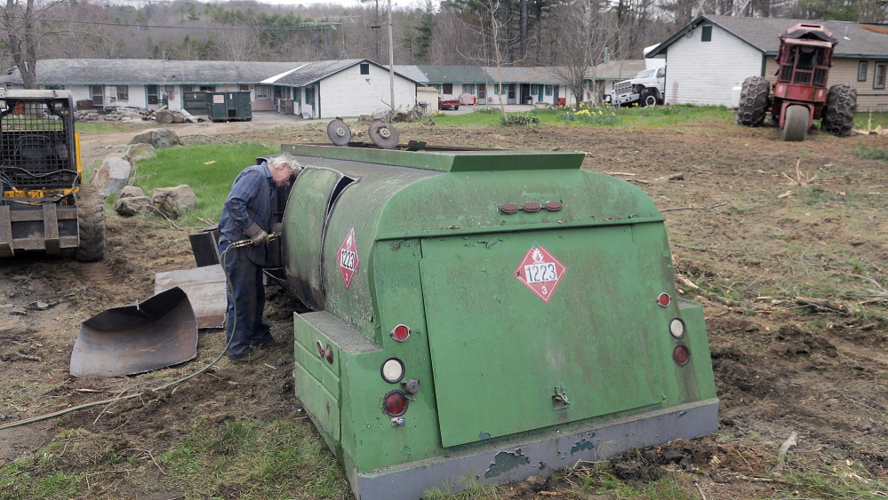 CLEAN-UP: Neal Maine cuts apart a fuel truck Tuesday at the Country Village Motel and Apartments in Augusta, part of the effort to clean up debris at the complex so it can comply with city codes.