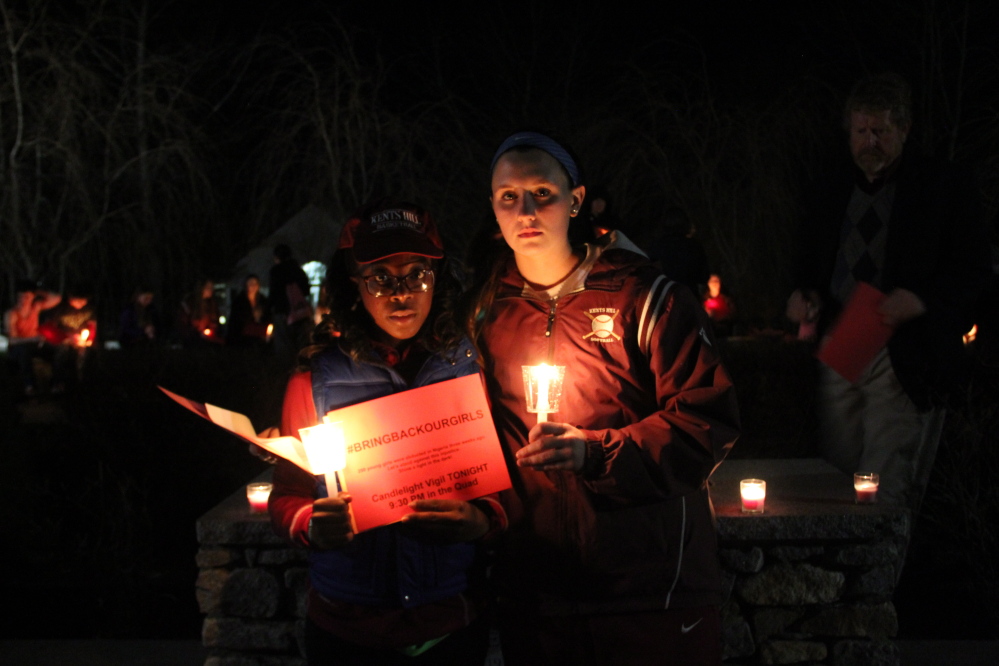 CALLING ATTENTION: Kents Hill School juniors Karrisha Gillespie, left, and Emma Curnin organized a vigil at the school on Tuesday night for Nigerian girls who have been kidnapped by an Islamic militant group.