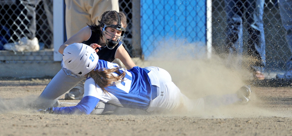 Staff photo by Michael G. Seamans Dirigo High School's Emma Lueders, 2, tags out Madison High School's Erin Whalen, 27, at third base in Madison on Wednesday. Madison defeated Dirigo 12-0 in six innings.