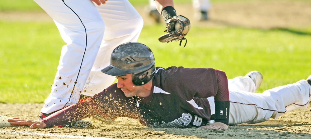 Monmouth Academy baserunner D.J. McHugh beats the tag from Hall-Dale first baseman Taylor Lockhart on pickoff play at first base during a game on Wednesday May 7, 2014 at Monmouth Academy. (Photo by Joe Phelan/Staff Photographer)