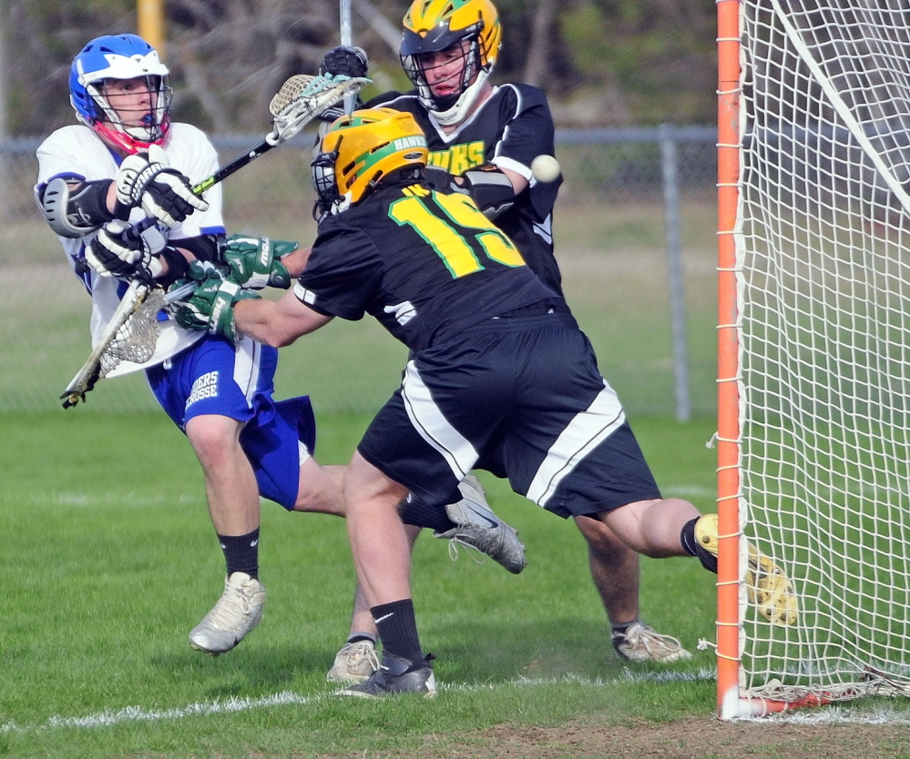 Oak Hill’s Matt Gilbert, left, shoots and misses as Maranacook-WInthrop keeper Zachary Bessette pushes him back during a game on Thursday May 8, 2014 at Oak Hill High in Wales.