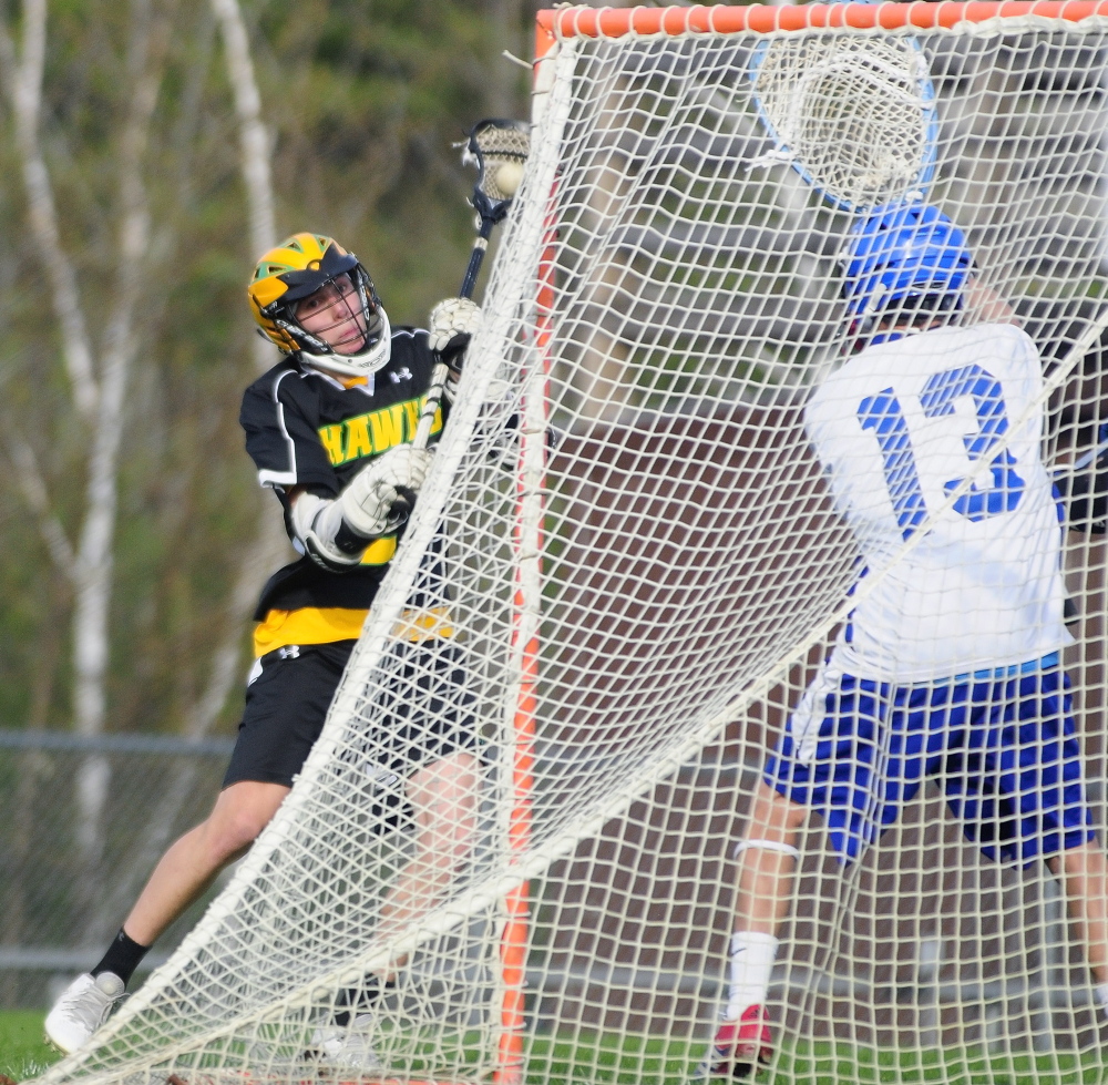 IT’S GOOD: Maranacook/Winthrop’s Toby Smith shoots on Oak Hill keeper Matty Martin to score the Hawk’s 12th goal Thursday in Wales.