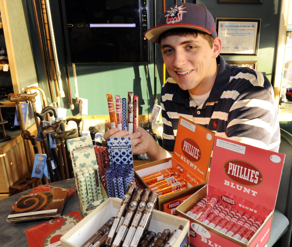 Cigar enthusiast Brendan Glennon poses with a display of candy-flavored cigars at a custom tobacco shop in Albany, N.Y., last May. Researchers at Portland State University have posted a letter in the New England Journal of Medicine stating that additives found in Jolly Rancher candies, Kool-Aid drink mixes and other sweets are being used in cigars.