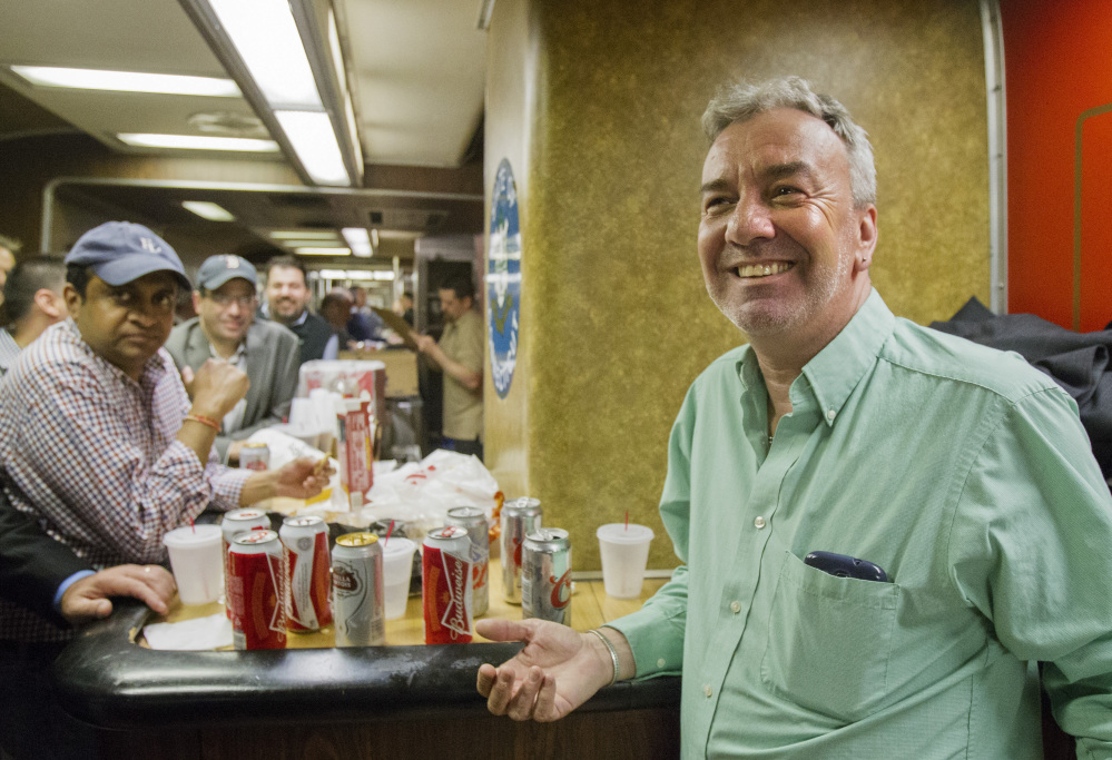 Mark DeMonte, right, of Wallingford, Conn., joins other riders in the bar car on the train to New Haven, Conn. DeMonte, a bar car regular, has been dubbed “Mayor of the 5:48” by friends and riders.