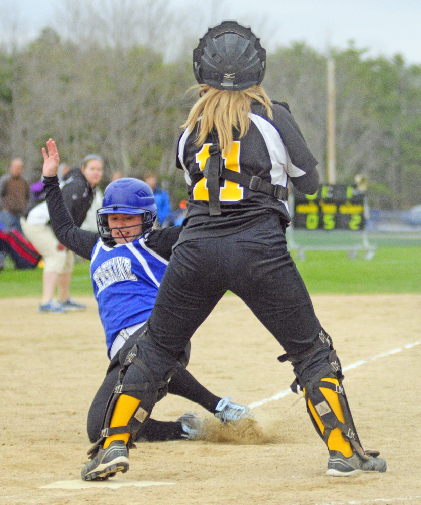 Erskine’s Cassandra Ray slides but is out at the plate as Maranacook catcher Ashley Michaud waits to tag her during a game on Friday.