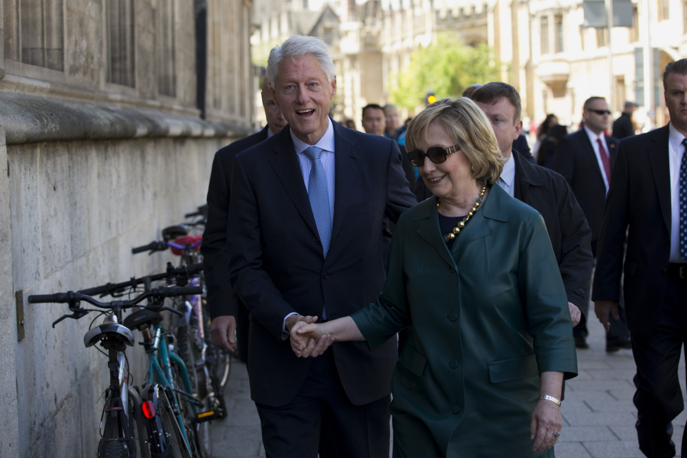 Former U.S. President Bill Clinton, left, and his wife former Secretary of State Hillary Rodham Clinton walk into a building entrance after they attended their daughter Chelsea’s Oxford University graduation ceremony held at the Sheldonian Theatre in Oxford, England, on Saturday.