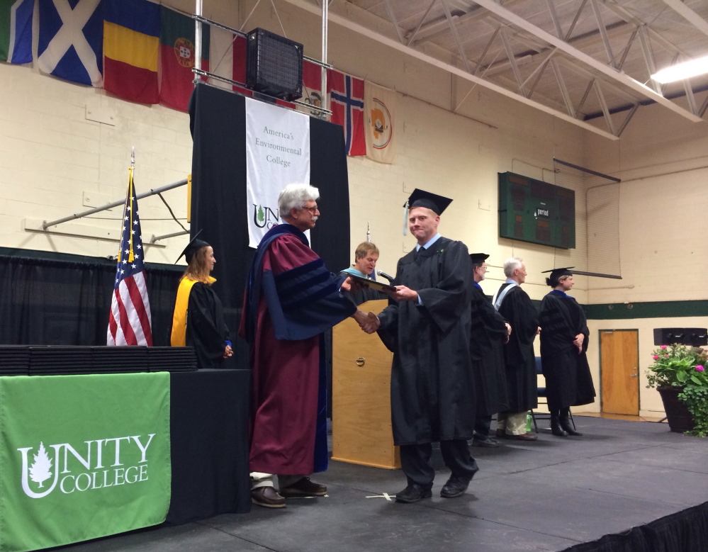 Unity College graduate Jacob A. Brodie '14, walks across the stage after receiving his diploma from President Stephen Mulkey at Saturday's commecement on May 10, 2014. Staff photo by Rachel Ohm.