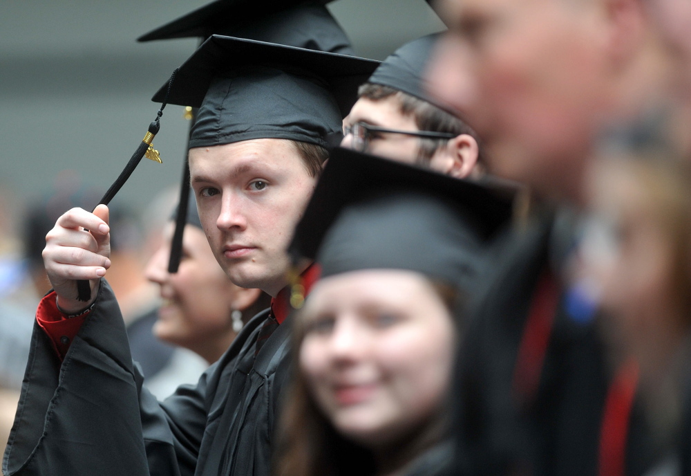 Diploma, please: Graduates wait to receive their degrees during the 120th commencement at Thomas College in Waterville on Saturday.