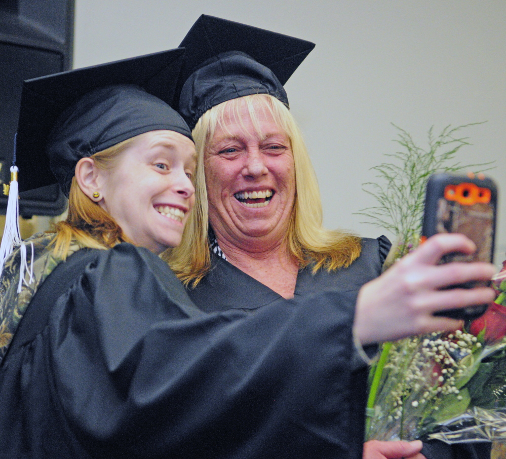 Staff photo by Joe Phelan RELATIVELY HAPPY: Nicole “Sis” Trask, left, of Hallowell takes a picture with her mother, Kathy Trask, before they walked in the University of Maine at Augusta graduation ceremony.