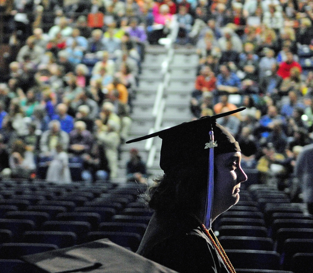 DIPLOMA-BOUND: A graduate marches in front of a large crowd during the University of Maine at Augusta graduation ceremony Saturday at the Augusta Civic Center.
