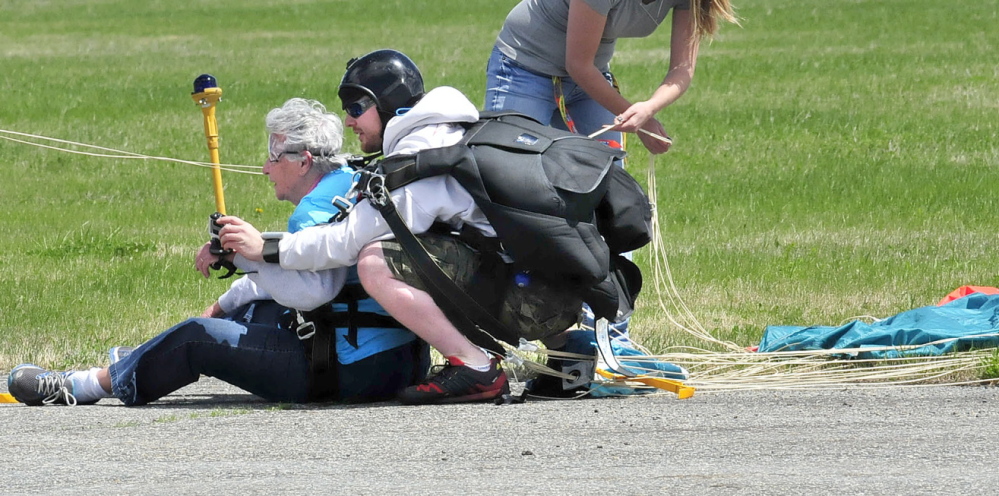 TERRA FIRMA: Marjorie Bell, 80, catches her breath seconds after landing with instructor Matt Riendeau after tandem skydiving at LaFleur Airport in Waterville on Sunday, May 11, 2014.