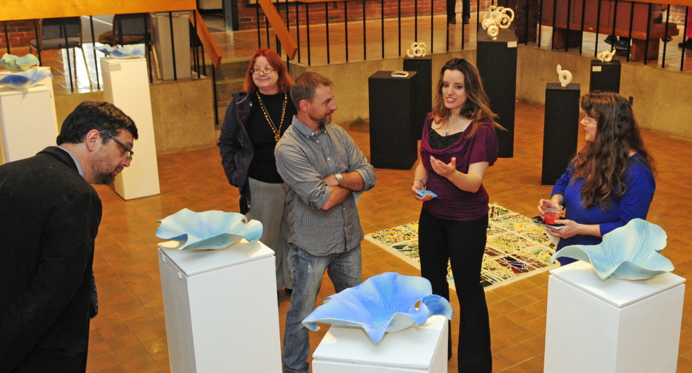 Porcelain: Adriana Love, second from right, talks about her blue porcelain pieces with visitors at the opening for the Senior Art Show on Saturday May 10, 2014 in the Danforth Gallery at the University of Maine at Augusta.