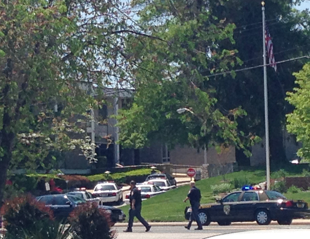 Police officers walk near WMAR-TV on Tuesday in Towson Md. Baltimore County police say a vehicle rammed a television station. A hole the size of several garage doors could be seen in the front of the building Tuesday afternoon.
