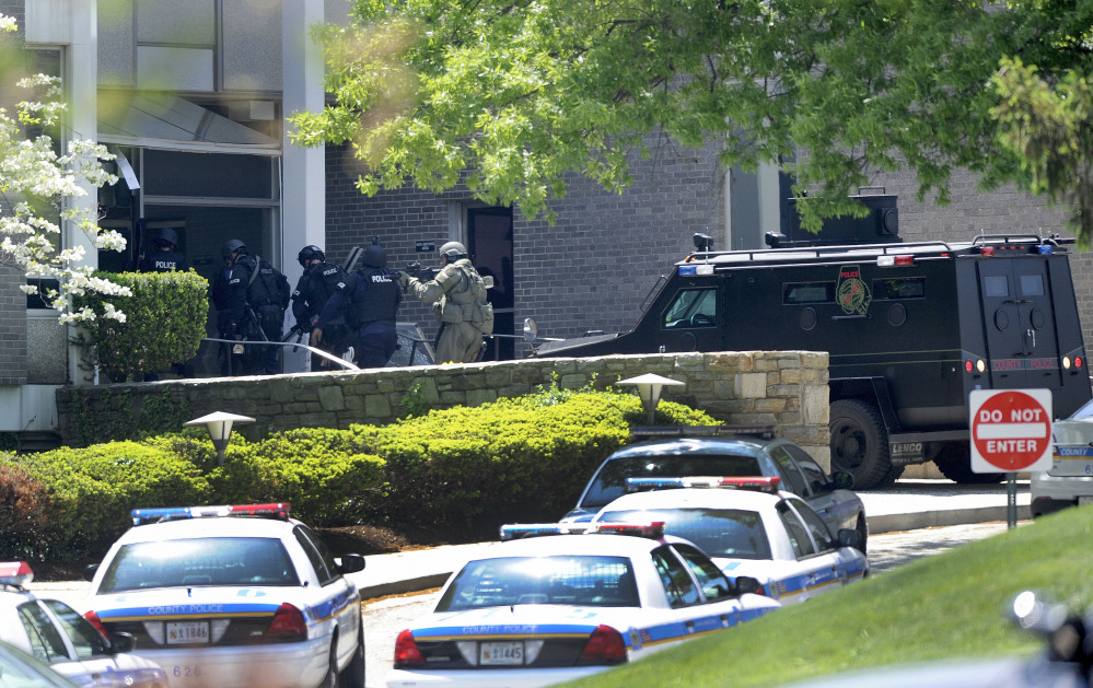 Police officers enter WMAR-TV, after a truck driven by a man rammed the Baltimore-area television station Tuesday, leaving a gaping hole in the front of the building, in Towson, Md.