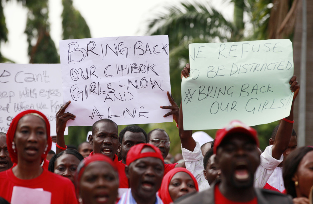 People attend a demonstration calling on the government to rescue the kidnapped schoolgirls of the Chibok secondary school, in Abuja, Nigeria, Tuesday, May 13, 2014. A Nigerian government official said "all options are open" in efforts to rescue almost 300 abducted schoolgirls from their captors as US reconnaissance aircraft started flying over this West African country in a search effort. Boko Haram, the militant group that kidnapped the girls last month from a school in Borno state, had released a video yesterday purporting to show some of the girls. A civic leader said representatives of the missing girls' families were set to view the video as a group later today to see if some of the girls can be identified. (AP Photo / Sunday Alamba)