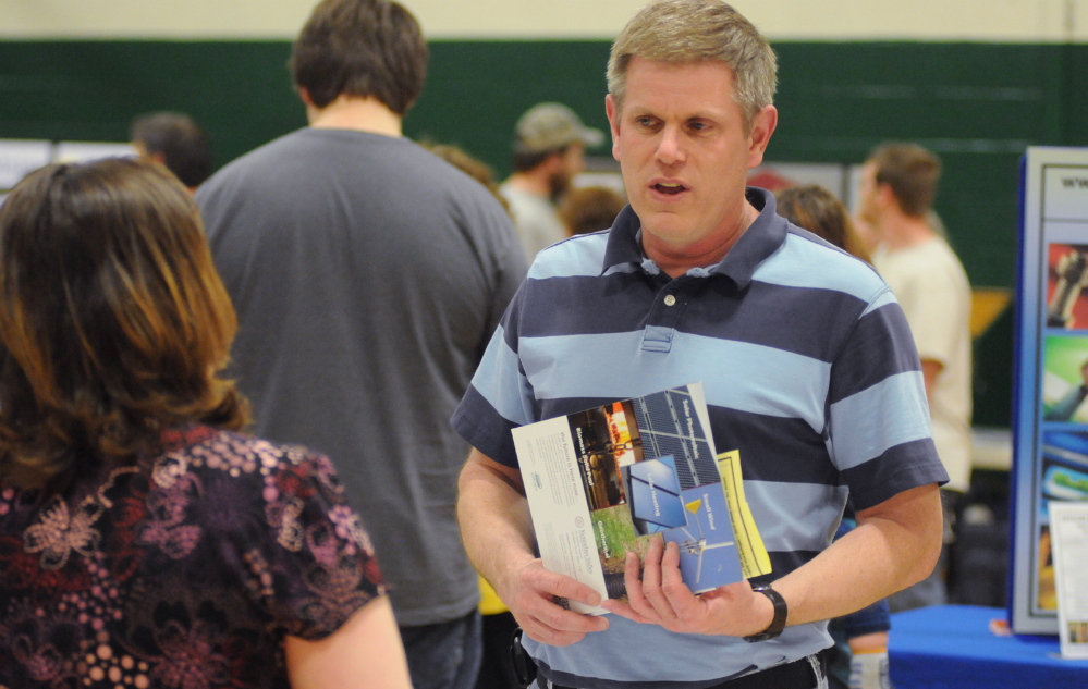 MAKING CONNECTIONS: United Technologies employee Jeffrey Carmichael of Pittsfield talks with senior tax examiner Maria French during the job fair in Pittsfield on Wednesday. Carmichael will lose his job when UTC closes next spring.