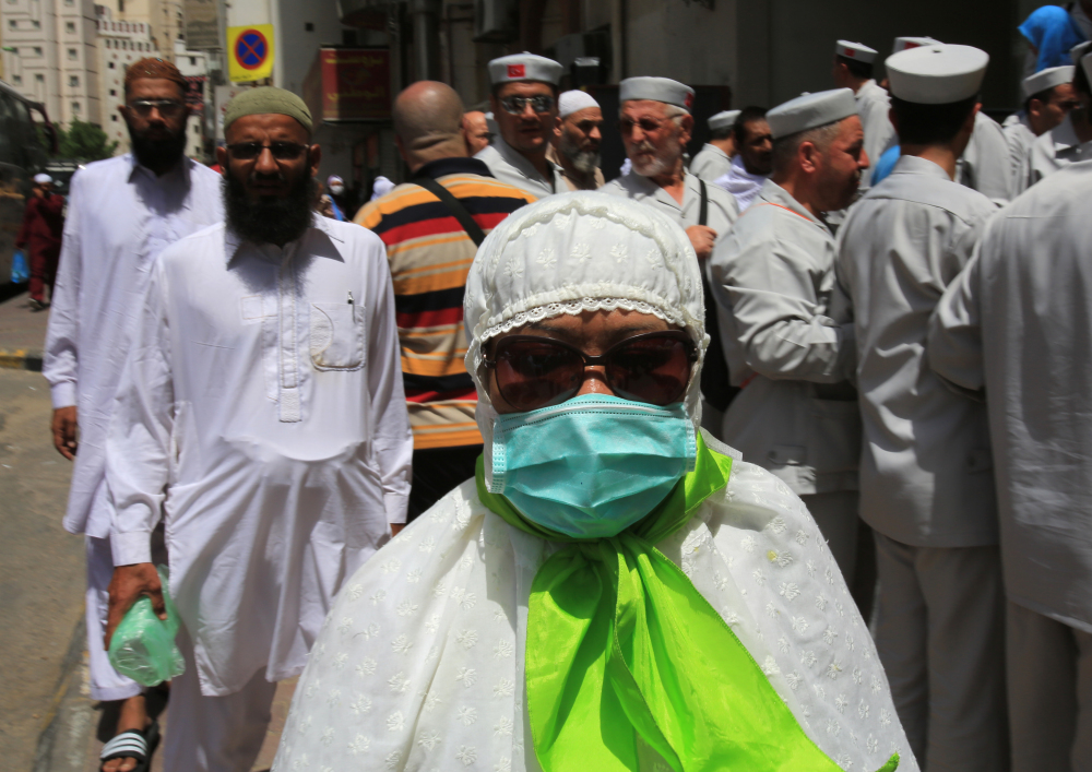 A Muslim pilgrim wears a surgical mask to help prevent infection from a respiratory virus known as the Middle East Respiratory Syndrome in the holy city of Mecca, Saudi Arabia, Tuesday. Saudi health authorities reported another five deaths Tuesday from MERS that has sickened hundreds and killed over 150 people.