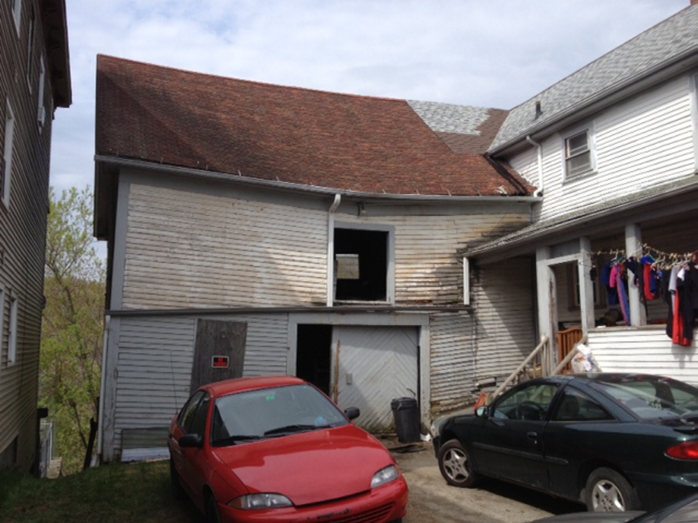 Displaced: Damage from a Tuesday night fire that in a Northern Avenue barn, seen here Wednesday, wasn’t very visible from the streeet, but forced two families living next door to evacuate.