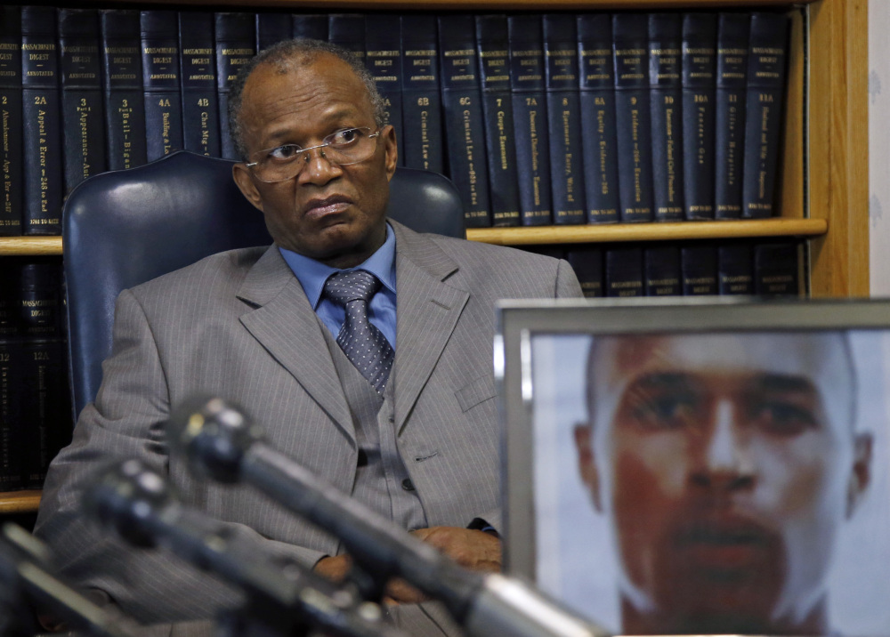 Salvadore Furtado listens during a news conference at his attorney’s office in Quincy, Mass. on Thursday, May 15, 2014, with a photo of his son, Safiro Furtado. Safiro and Daniel de Abreu were shot to death as they sat in a car in Boston’s South End on July 16, 2012. Former New England Patriots’ Aaron Hernandez has been indicted Thursday on new murder charges in this 2012 double slaying.