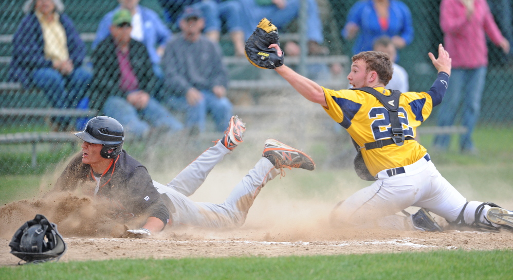 Staff photo by Michael G. Seamans YOU’RE OUTTA HERE: Mt. Blue High School catcher Andrew Pratt, 22, tags out Skowhegan High School’s DJ Allen, 22, on Friday.