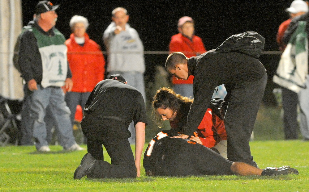 Helping the Injured: Trainers from Cony High School and Skowhegan High School tend to an injured Skowhegan player in Skowhegan Oct. 4, 2013.