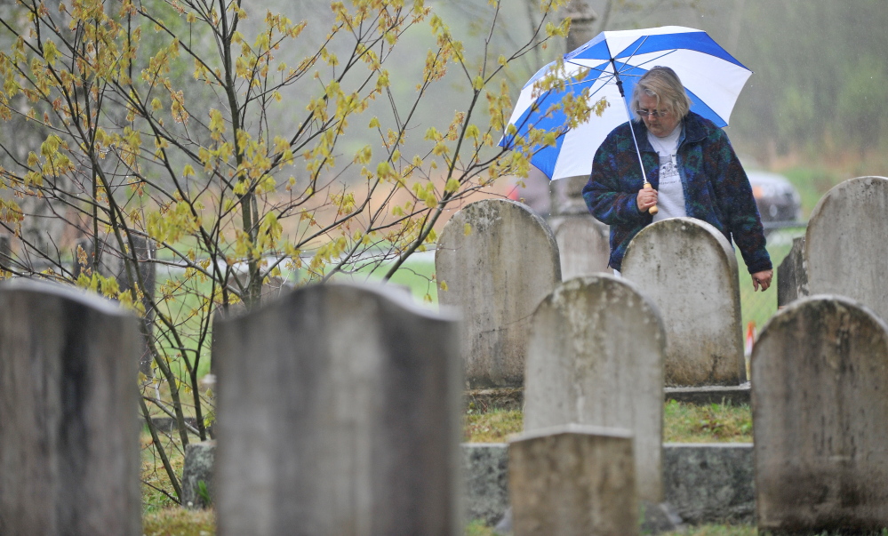 It’s set in stone: Elsie Bonney, of Bethel, reads the headstones Saturday at Frederic Cemetery in Starks. The Maine Old Cemetery Association, which works to preserve old cemeteries, held its annual spring meeting in Starks.